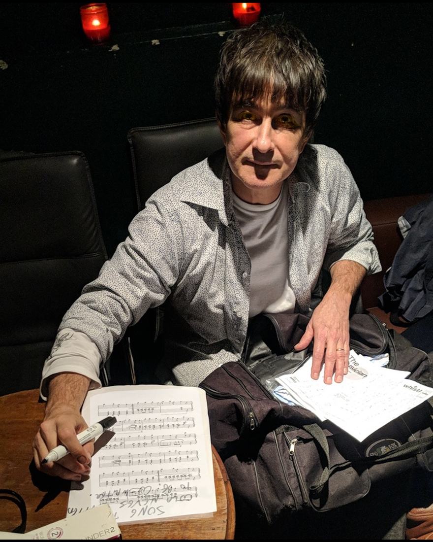 Gui Tavares marking up a handwritten score at a table before a show